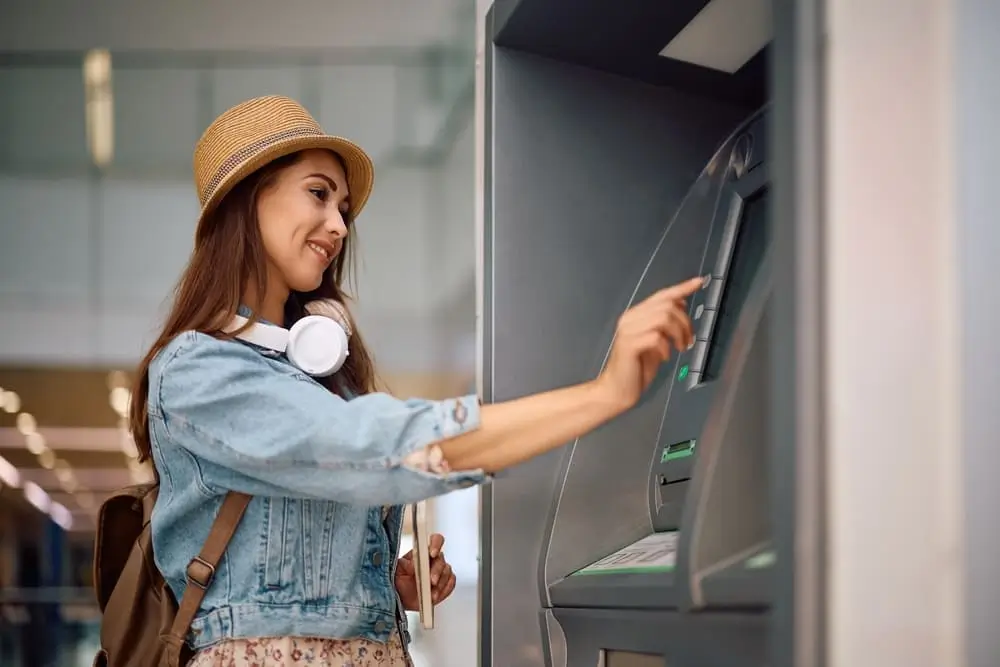 una mujer feliz usando un cajero electrónico