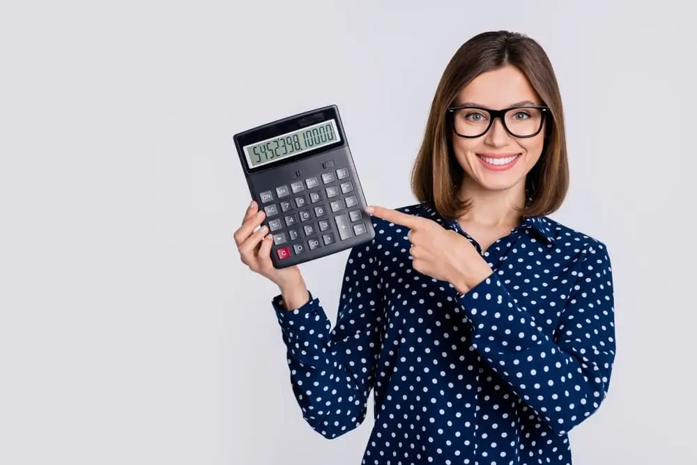 mujer sosteniendo una calculadora de prestamos