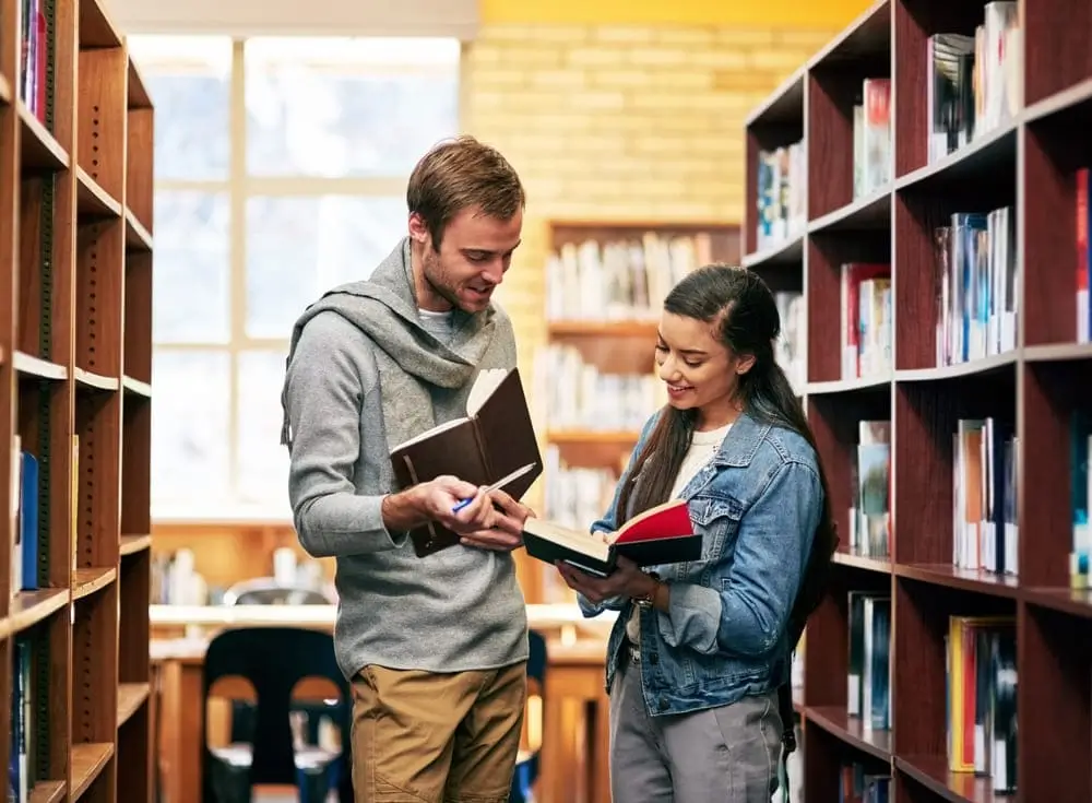 personas estudiando en la bliblioteca de  una universidad del exterior