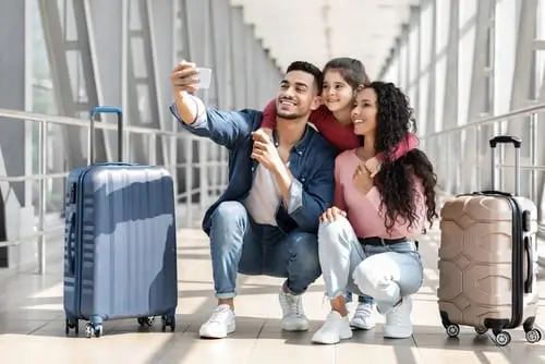 una familia de 3 personas preparandose para su viaje en un aeropuerto