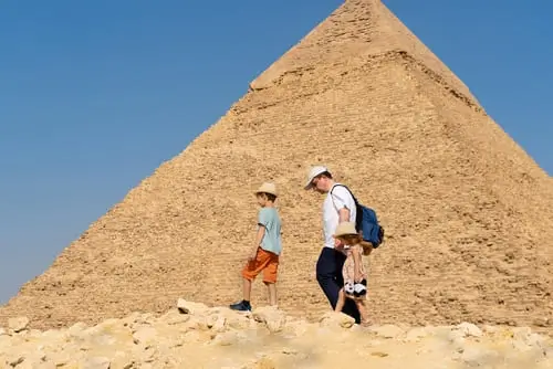 un padre y su hija e hijo en caminando al rededor de una piramide en egipto