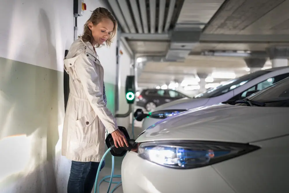 Vehículo eléctrico recargando con luces prendidas