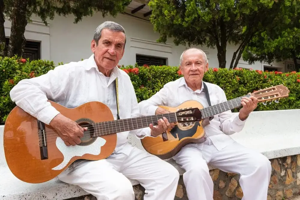 Dos adultos mayores aprendiendo a tocar la guitarra